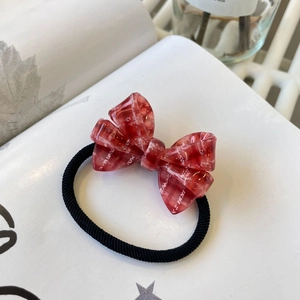 Détail d'un nœud papillon en acrylique à carreaux rouges avec élastique noir robuste
