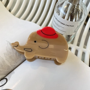 Dettaglio del fermaglio per capelli a forma di elefante con cappello rosso