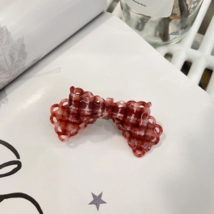 Pince à cheveux vintage à carreaux rouges avec détails en dentelle sur fond blanc