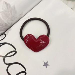 Handmade red heart-shaped acetate hair tie with gold lettering on black elastic band