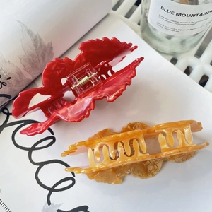 Detail of red marble and amber acetate hair claws set with metallic spring clips