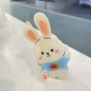 Gros plan détaillé d'une pince à cheveux lapin en acétate blanc avec détail carotte