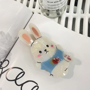 Détail de la pince à cheveux lapin en acétate avec accent fraise sur fond de style de vie