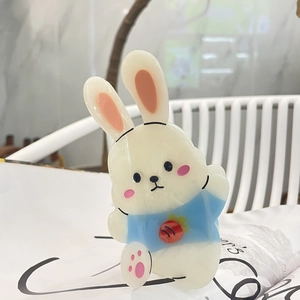 Détail d'une pince à cheveux lapin blanc en acétate avec des motifs de carottes
