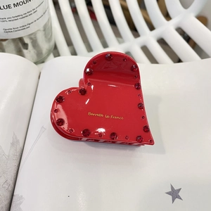 Pince à cheveux élégante en forme de cœur rouge avec strass et lettrage doré sur fond blanc