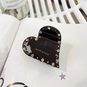 Vue détaillée d'une pince à cheveux cœur noir brillant avec strass et lettrage doré