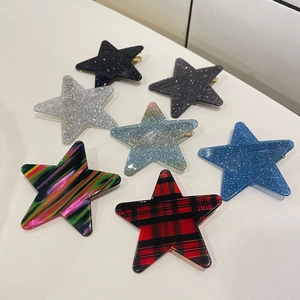 Flache Darstellung bunter Stern-Haarklammern mit Glitzerpailletten und Karomuster