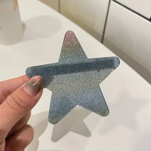 Detailaufnahme einer Haarspange in Sternform mit rosa Farbverlauf und Glitzerharz