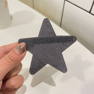 Nahaufnahme einer Y2K Haarspange in Sternform mit dunkelgrauem Glitzer-Finish und Glanz