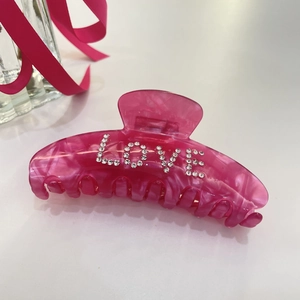Pinza per capelli in acetato rosa con scritta LOVE in cristalli e trama marmorea