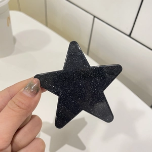 Nahaufnahme einer schwarzen Stern-Haarklammer mit silbernem Glitzer und Glanzfinish