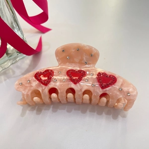 Pinza per capelli in acetato rosa con cuori di strass e trama marmorizzata da donna
