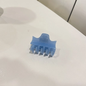 Détail macro d'une pince à cheveux en acétate bleu clair avec paillettes et cœur