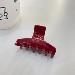 Detail view of burgundy acetate hair claw clip with golden Barrette La France lettering