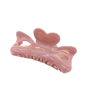Pink heart-shaped hair claw clip with golden glitter and hollow cutout design
