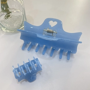 Détail de pinces à cheveux coeur bleu clair pailleté en grand et petit format sur blanc