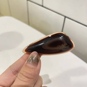 Detail of dark brown acetate hair clip with tortoise shell pattern and gold handmade text
