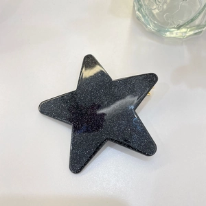 Detailansicht einer Y2K Haarklammer in Sternform aus schwarzem Harz mit Silberglitzer-Finish