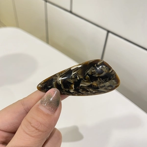Detailed close-up of tortoise shell pattern hair clip with gold France Handmade logo