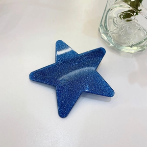 Detailansicht einer dunkelblauen Glitzer-Sternhaarklammer auf weißem Hintergrund