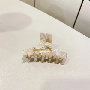 Detail view of acetate marble hair claw clip with Barrette la Fra lettering