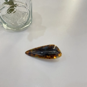 Detailed macro view of tortoiseshell hair clip with golden France Handmade engraving