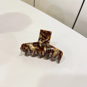 Detail showing tortoise shell acetate hair claw with Barrette La France gold lettering