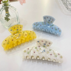 Three-piece acetate hair claw clips in yellow, blue, and cream with sparkling star rhinestones