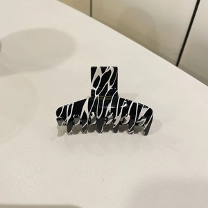 Detailed view of the premium acetate hair claw clip with black and white marble patterns
