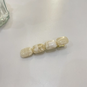 Barrette élégante en résine marbrée crème avec base en métal doré pour un look chic épuré
