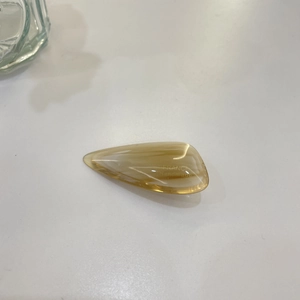 Detailed macro view of amber marble hair clip with gold France Handmade lettering