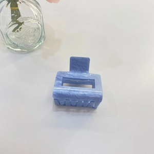 Dettaglio della molletta per capelli quadrata con texture in marmo blu e design vuoto