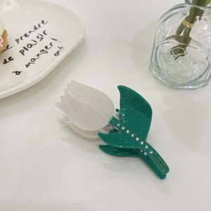 Detailed view of tulip hair claw clip with green leaf and rhinestone embellishments