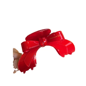 Elegant red acetate hair claw clip with a 3D bow design and gold handmade lettering