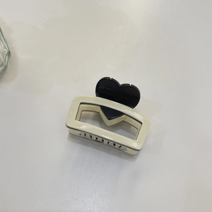 Elegant cream acetate hair claw clip with black heart pattern and hollow rectangular base