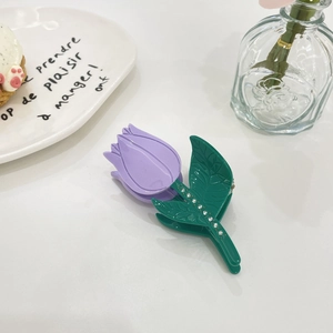 Detailed shot of tulip hair claw clip with purple petals and rhinestone green leaves