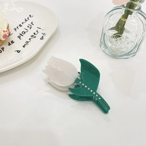 Detailed view of tulip hair claw clip with white petals and sparkling rhinestones