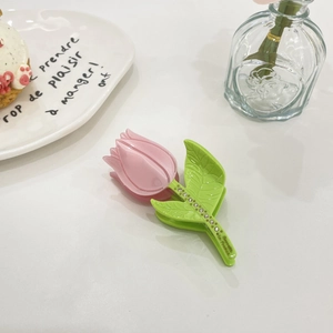 Detail of pink tulip hair claw clip with green leaf and sparkling crystal accents