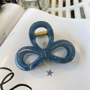 Elegant navy blue bow hair claw clip with gold metal spring for a stylish back head look