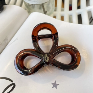 Detail of tortoiseshell acrylic hair claw clip with a glossy amber floral design