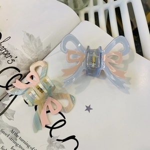 Detailed close-up of bow-shaped hair claws made of high-quality acrylic with ribbon accents