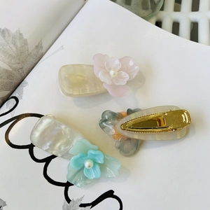 Détail macro de pinces à cheveux florales en résine nacrée avec accents de perles