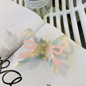 Detail of pink and blue marble bow hair claw clip with golden metal spring