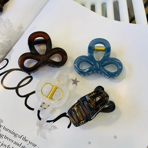 Detail of elegant bow-shaped hair claws in tortoiseshell and morandi colors on magazine