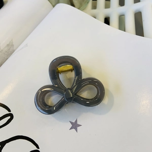 Detailed top view of grey translucent butterfly hair claw with a gold metal spring