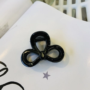 Detailed view of shiny black butterfly hair claw clip with strong metal spring