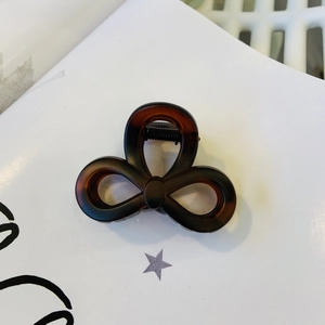 Detailed close-up of dark brown tortoiseshell hair claw clip with triple loop design