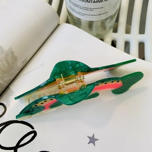 Detail of a fish-shaped acetate hair claw with trout pattern and gold metal spring