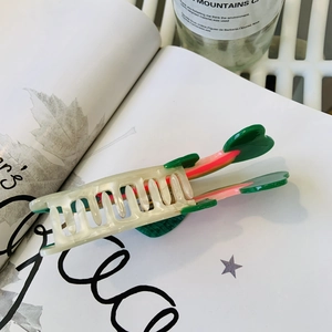 Macro detail of acetate cactus claw clip with forest green and peach pink tones