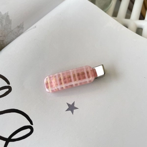 Chic pink plaid acrylic hair clip with metal duckbill buckle on a white magazine background
